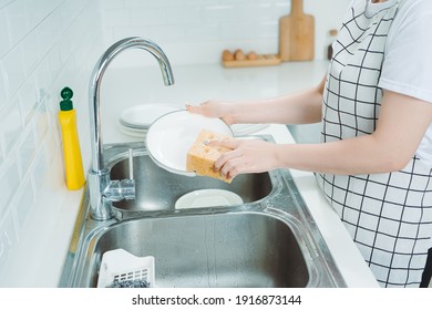 Woman washing plate in modern kitchen, closeup