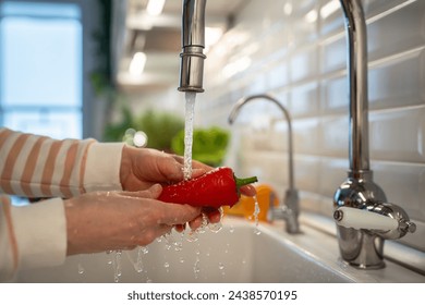 Woman washing of red ramiro pepper under tap water closeup. Healthy tasty raw sweet fresh fruit and vegetables full of vitamins, used for salad cooking. Natural nutrition - Powered by Shutterstock