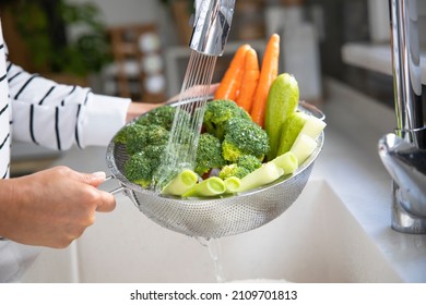 Woman washing vegetables on kitchen counter
 - Powered by Shutterstock