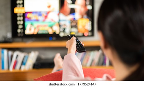 Woman Watch Tv At Home And Using The Remote
