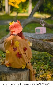 Woman Watches A Small Retro TV On The Park. Autumn Outdoor Recreation. Concept