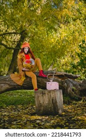 Woman Watches A Small Retro TV On The Park. Autumn Outdoor Recreation. Concept