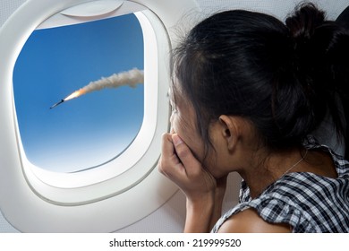 Woman watching a rocket from airplane. Terrified passenger in a flying aircraft watching racket. Missile attack on an airliner.  - Shutterstock ID 219999520