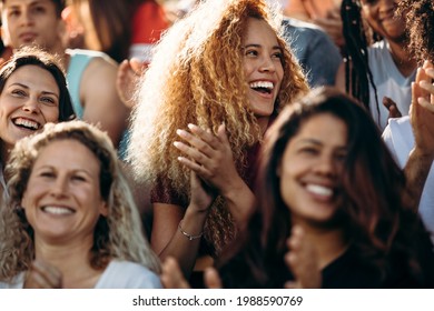 Woman watching a sport event and clapping. Excited sports fan applauding and celebrating her team's victory.