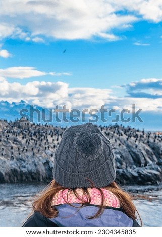 Woman watching from trip excursion king cormorants colony at famous les eclaireurs lighthouse, ushuaia, argentina tierra del fuego, argentina