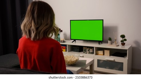 Woman Watching TV Focused Eating Popcorn. Green Screen TV Chroma Key.