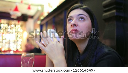 Woman watching TV screen at restaurant bar