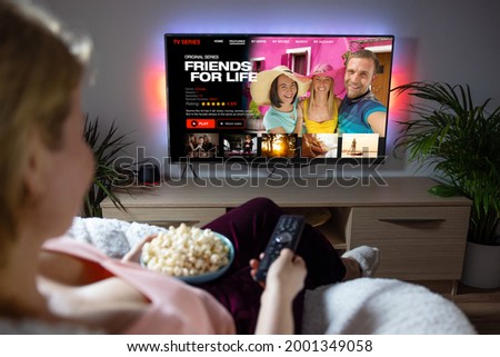 Woman watching TV series and movies on online streaming service at home