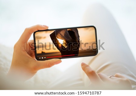 Woman watching video on mobile phone