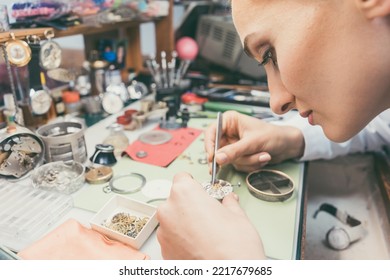 Woman Watchmaker Working Diligently On Repairing A Watch