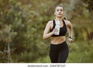 Woman, water bottle and running in nature for fitness, workout or outdoor exercise with hydration. Active person, athlete or runner and natural mineral drink for training, nutrition or sustainability - Powered by Shutterstock