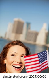 Woman Waving American Flag By City Cityscape