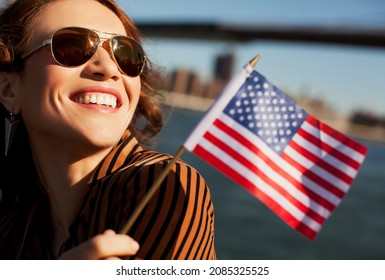 Woman Waving American Flag By Urban Bridge