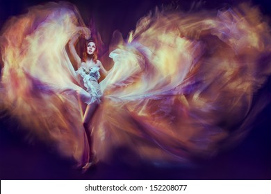 Woman in waving dress as a flame dancing with flying fabric. Dark background