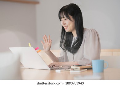 A Woman Waving Her Hand To Greet The Computer Screen