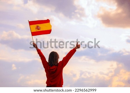
Woman Waving Spanish Flag Looking at the Sky. Optimistic girl holding national flag celebrating citizenship
