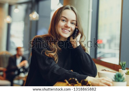 Woman Wear Glasses, Talk At Phone, Drink Her Hot Coffee While Work In Cafe On Her Laptop. Portrait Of Stylish Smiling Woman In Winter Clothes Drinking Hot Coffee And Work At Laptop. - Image