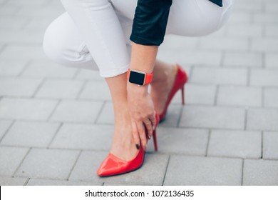 Woman Wear Smart Watch On Hand, Red Strap And Red Shoes