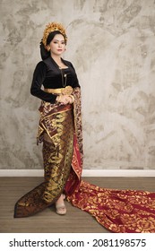 woman wearing Balinese Kebaya woven cloth with patterned wall background