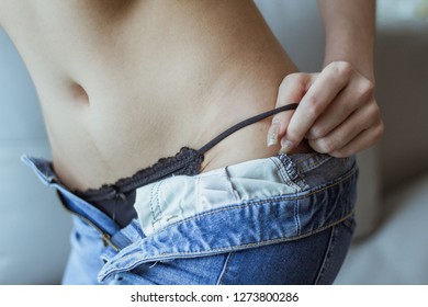 Woman Wearing Black Underwear. Are Removing Jeans In A Bedroom At Home , Soft Focus , Blurred.