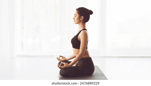A woman wearing a black top is practicing yoga poses outdoors. She is focused and balanced, engaging in various stretches and movements to improve flexibility and strength, copy space