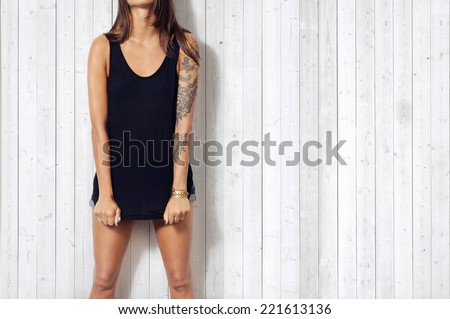 Woman wearing black vest. Wood wall background.