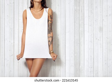 Woman wearing blank sleeveless t-shirt. Wood wall background.