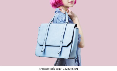 Woman Wearing Blue Dress And Pink Wig Holding Big Pastel Plue Messenger Bag Over White Background