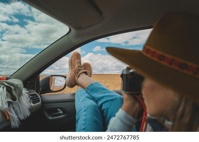 A woman wearing a brown hat is taking a picture of herself while laying in a car. Huayllay Stone Forest, Peru. - Powered by Shutterstock