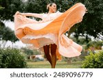 Woman wearing a colorful dress is dancing the traditional peruvian marinera dance in a park