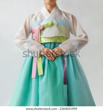 The woman wearing colorful Hanbok, Korean traditional dress with her hands together. Isolated on white background. Holiday greeting concept.
