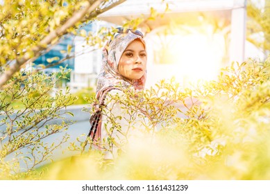 Woman wearing conservative Hijab fashion posing to a camera during portraiture session. The female wearing religious muslim outfit represents individualism, feminism and ethnic and racial acceptance. - Powered by Shutterstock