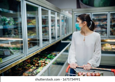 Woman Wearing Face Mask Buying In Supermarket.Panic Shopping During Coronavirus Covid-19 Pandemic.Budget Buying At A Supply Store.Buying Freezer Smart Purchased Household Pantry Groceries