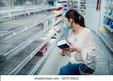 Woman wearing face mask buying in supermarket/drugstore with sold-out supplies.Preparation for a pandemic quarantine due to coronavirus covid-19 outbreak.Hygiene, cleaning and disinfection products.