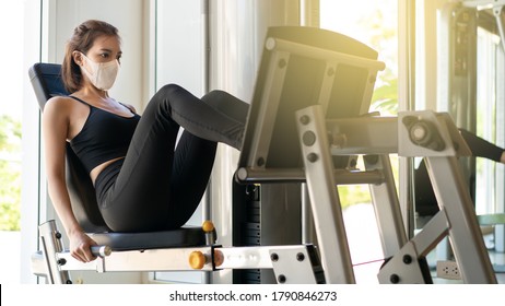 Woman wearing face mask exercising with leg press machine in gym. during corona virus pandermic. - Powered by Shutterstock