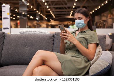 Woman Wearing Face Mask At Furniture Store, Using Her Smart Phone