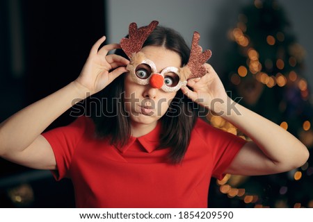 
Woman Wearing Funny Christmas Party Glasses. Silly girl in disguise eyeglasses having fun on holidays
