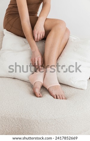 Woman wearing gel heel treatment socks