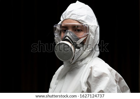 Woman wearing gloves with biohazard chemical protective suit and mask.