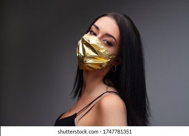 woman wearing a golden face mask - concept of surgical masks price rise when they are mandatory and as extremely rare as they are needed to mitigate the COVID19 virus pandemic spread