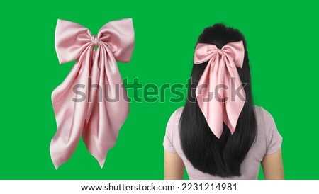 A woman wearing hair bow made out of silk satin fabric with bow design and green background. This beautiful bow with long tails is a great hair accessory.