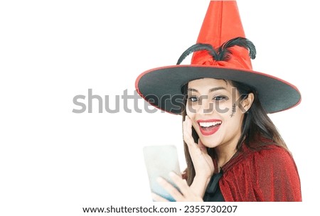 Woman wearing Halloween costume as witch in red cloak, on white background with copy space, holding smartphone for online shopping event on Halloween day trick or treat