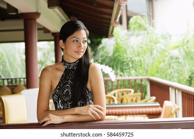 Woman Wearing Halter Top, Leaning On Railing, Arms Crossed