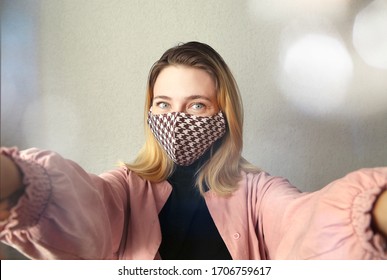 Woman wearing  handmade cloth cotton face mask at home. Protect against corona virus. Quarantine concept. Reusable face mask.