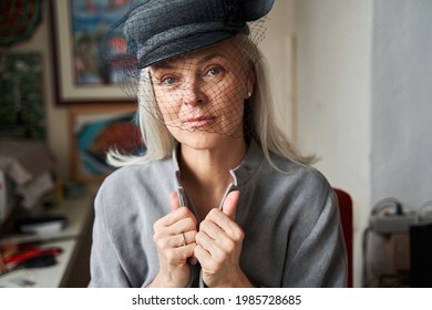 Woman wearing handmade hat with veil looking at the camera while posing - Powered by Shutterstock