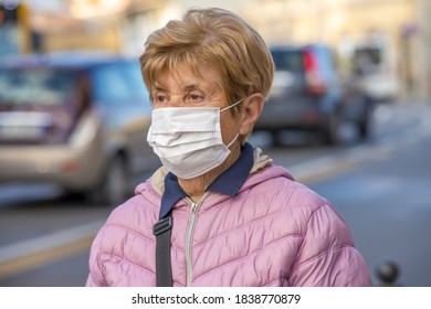 Woman wearing health mask in the city traffic in covid pandemic.