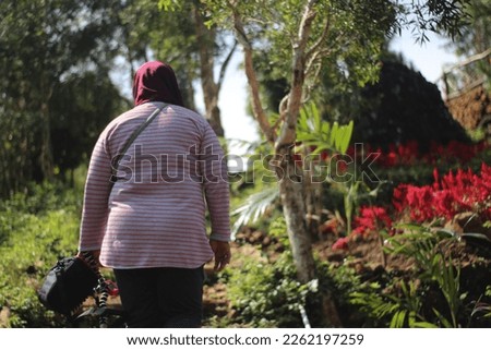 a woman wearing a hijab walks up the hill