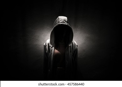 Woman wearing hoodie hiding in the dark,Scary background for book cover