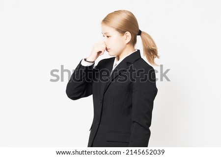 A woman wearing a jacket and having trouble with the smell