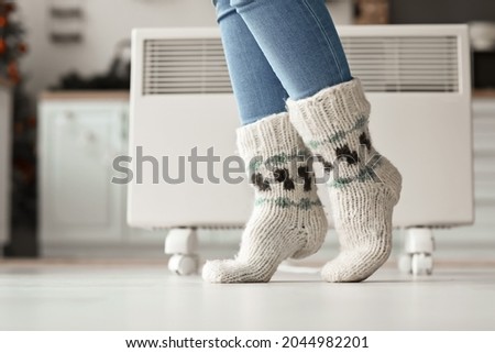 Woman wearing knitted socks at home. Concept of heating season